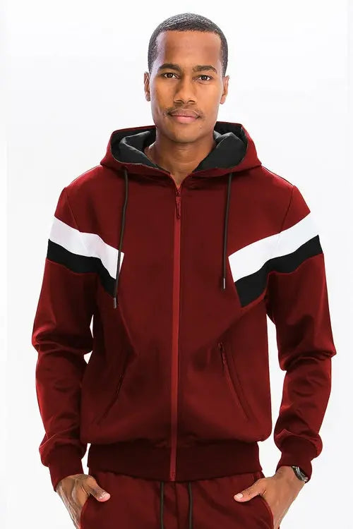 Man wearing a Maroon tracksuit with white and black stripes